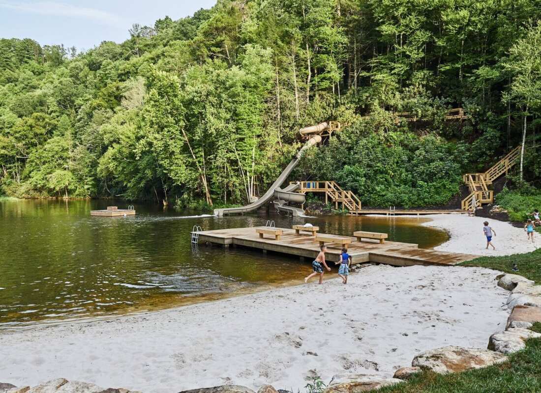 Woodland swimming pond with a sandy beach and wooden dock at Blackberry Mountain, Walland, USA