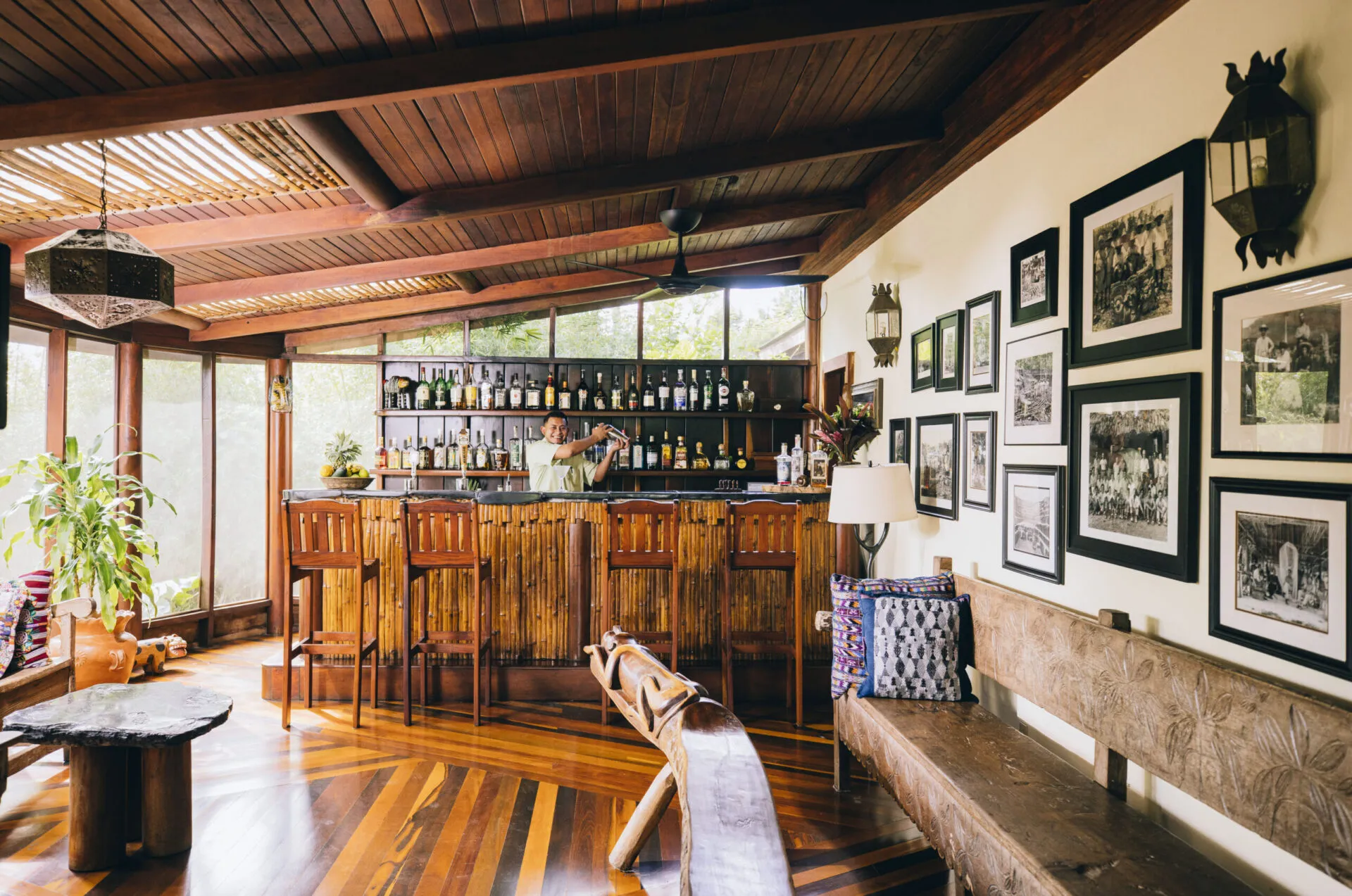 Wood-paneled lounge and bar with framed photographs, Blancaneaux Lodge, Mountain Pine Ridge, Cayo, Belize