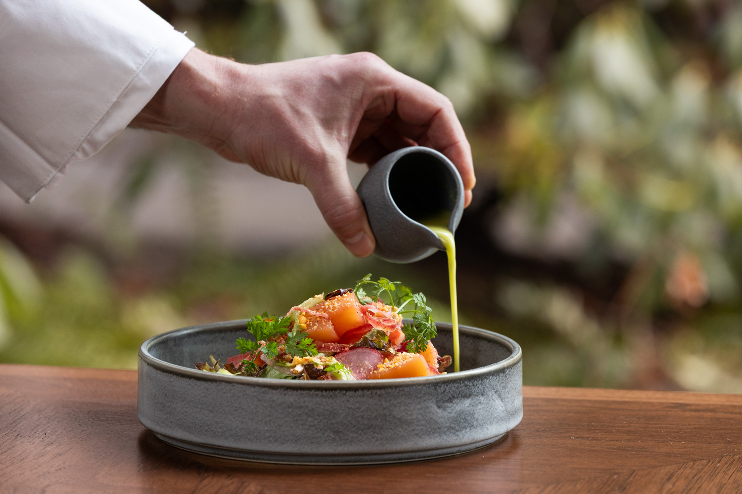 Chef dressing a colourful plated salad at The Wildflower, Fairmont Chateau Whistler, British Columbia, Canada