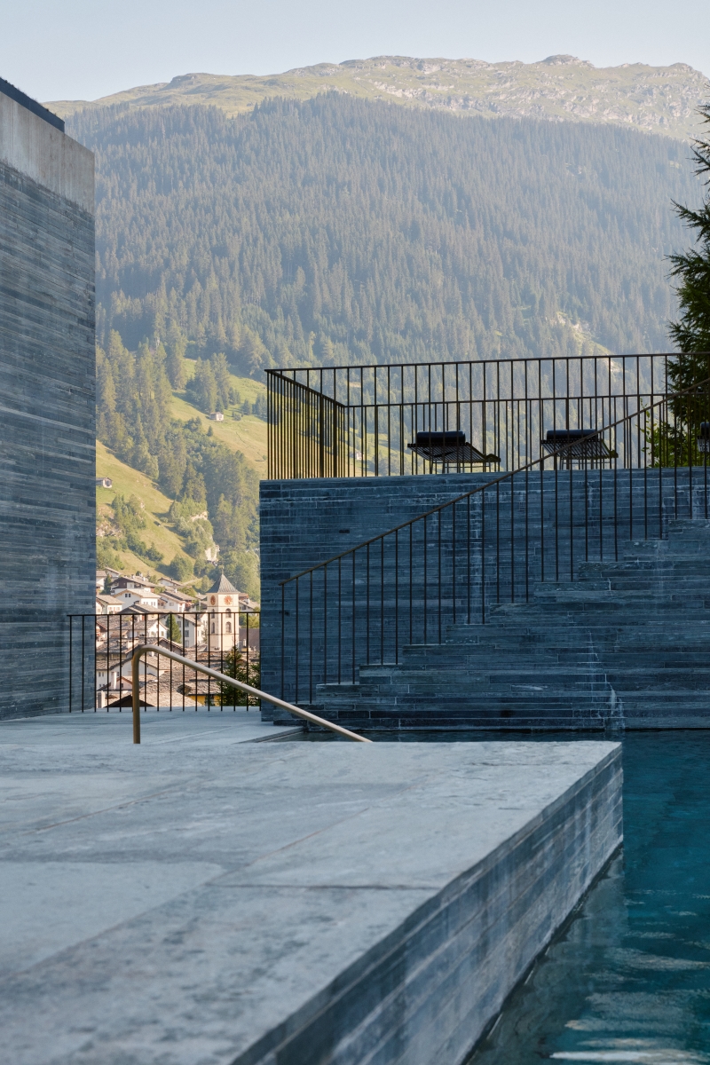 Quartzite walls and steps beside the outdoor thermal pool with mountains beyond at 7132 Hotel, Vals, Switzerland