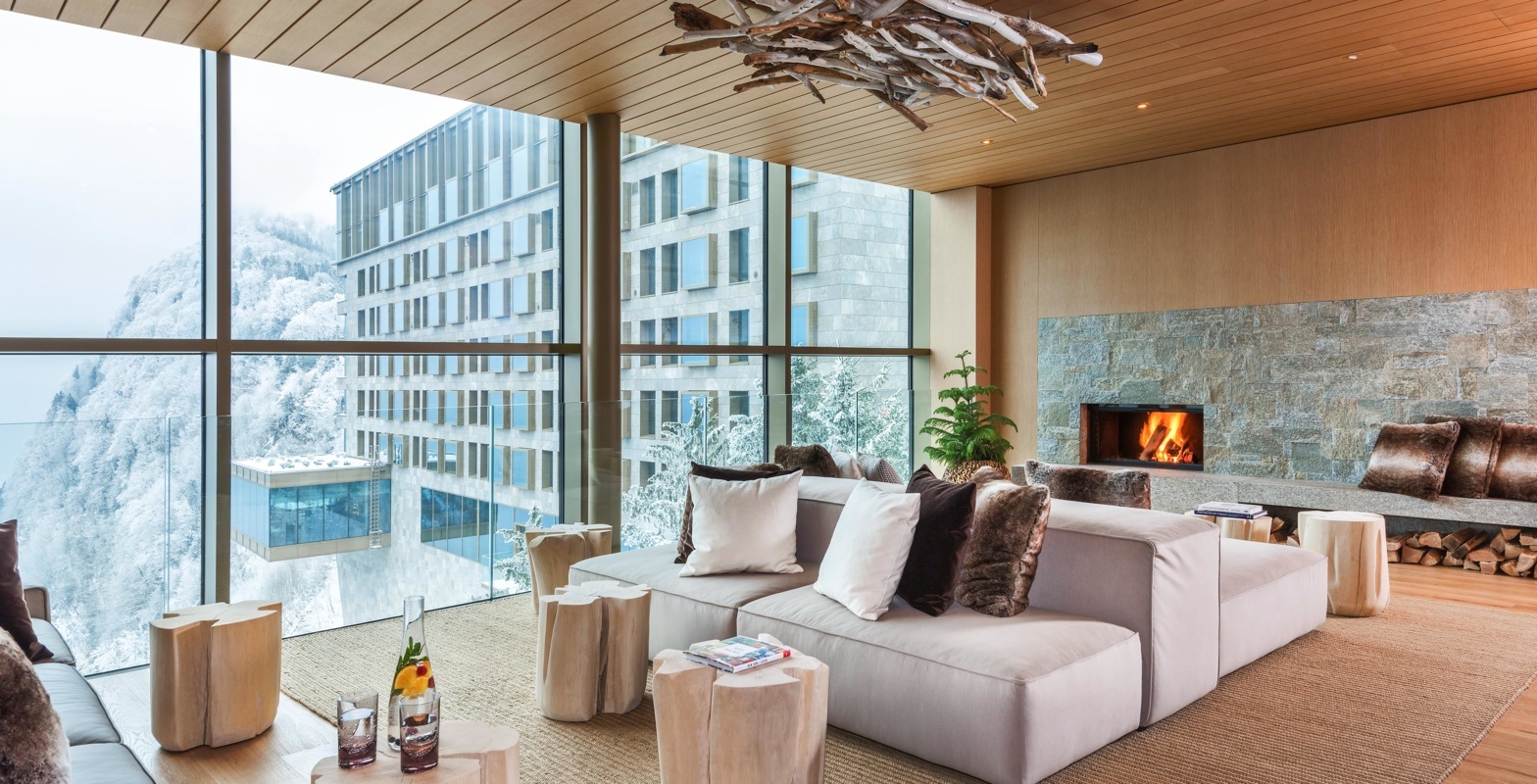 Lounge with fireplace and floor-to-ceiling windows at Bürgenstock Resort, Lake Lucerne, Switzerland