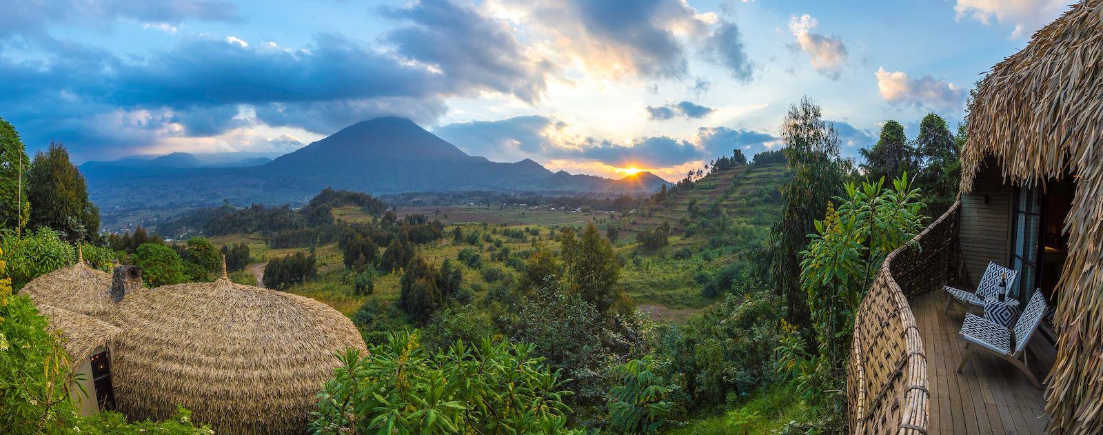 Thatched lodge exterior overlooking volcanoes at sunset, Bisate Lodge, Volcanoes National Park, Rwanda