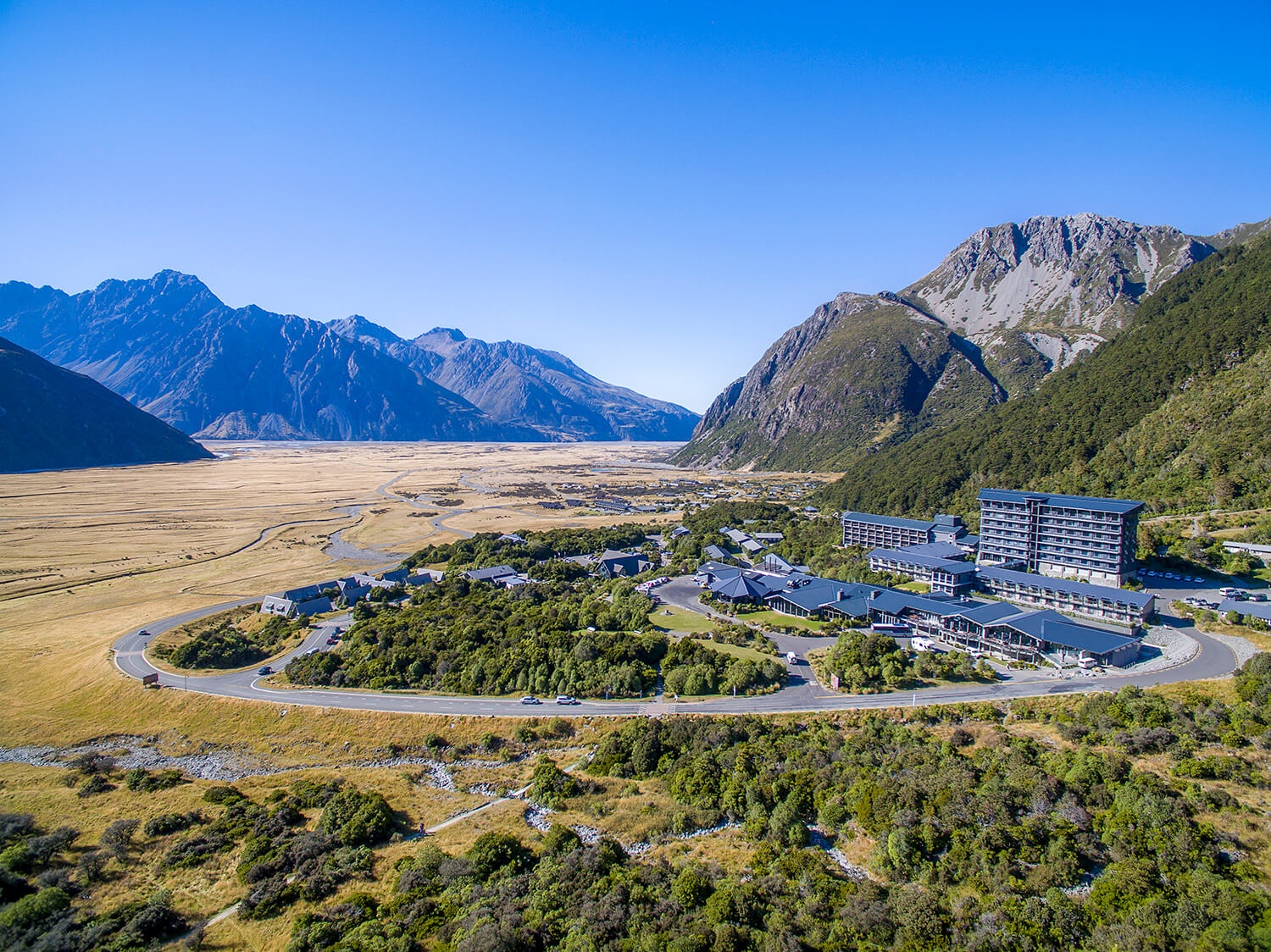 Aerial view of the Hermitage buildings and village in a broad mountain valley, Aoraki/Mount Cook, New Zealand