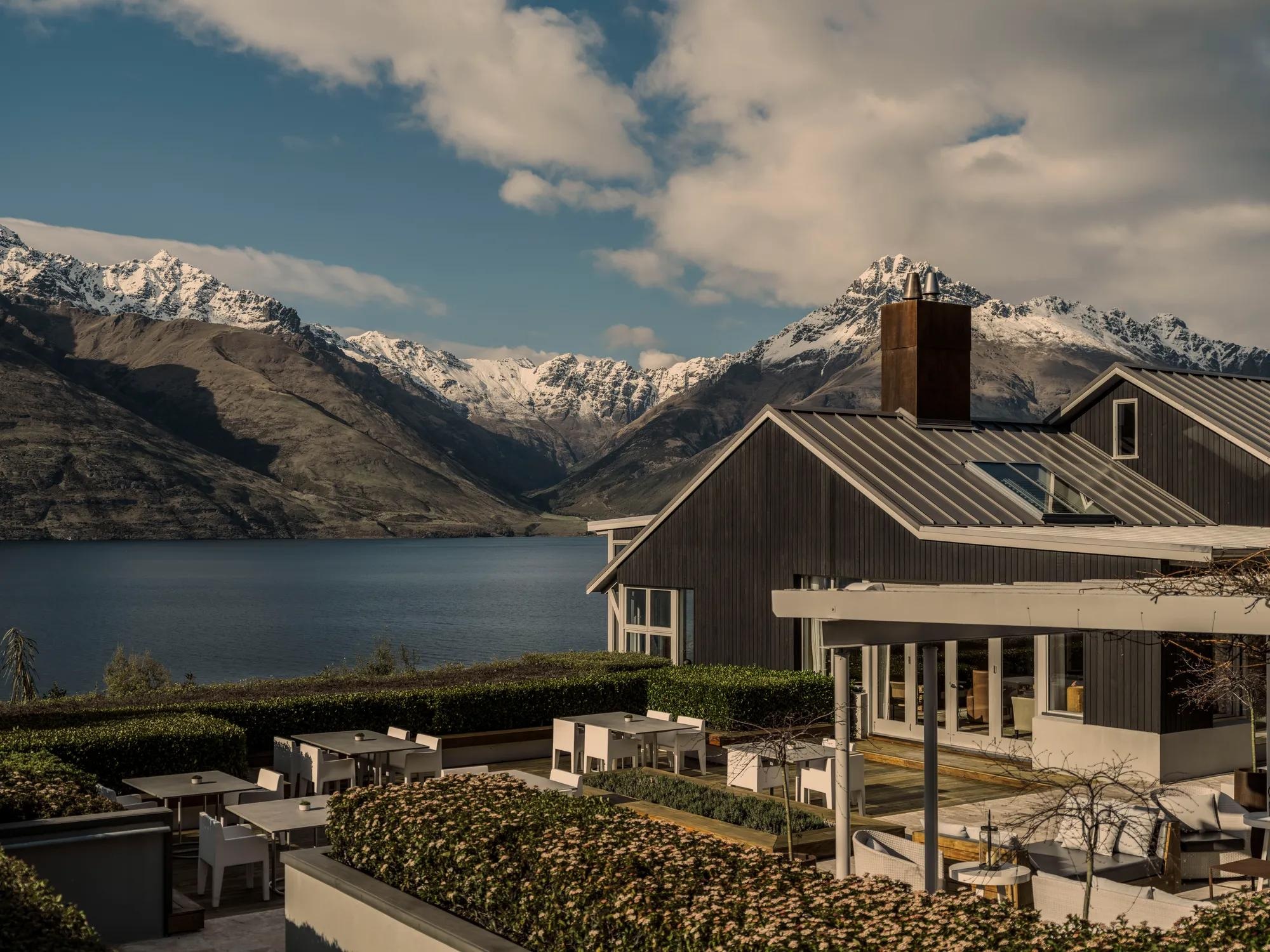 Lakeside main lodge and snow-capped mountains at Matakauri Lodge, Queenstown, New Zealand