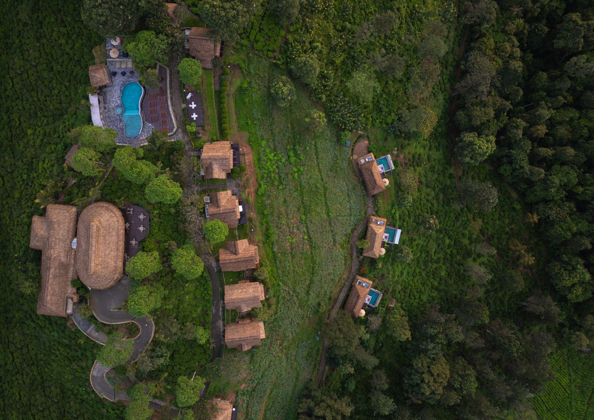 Aerial exterior view of hillside cottages and pools surrounded by greenery, 98 Acres Resort, Ella, Sri Lanka
