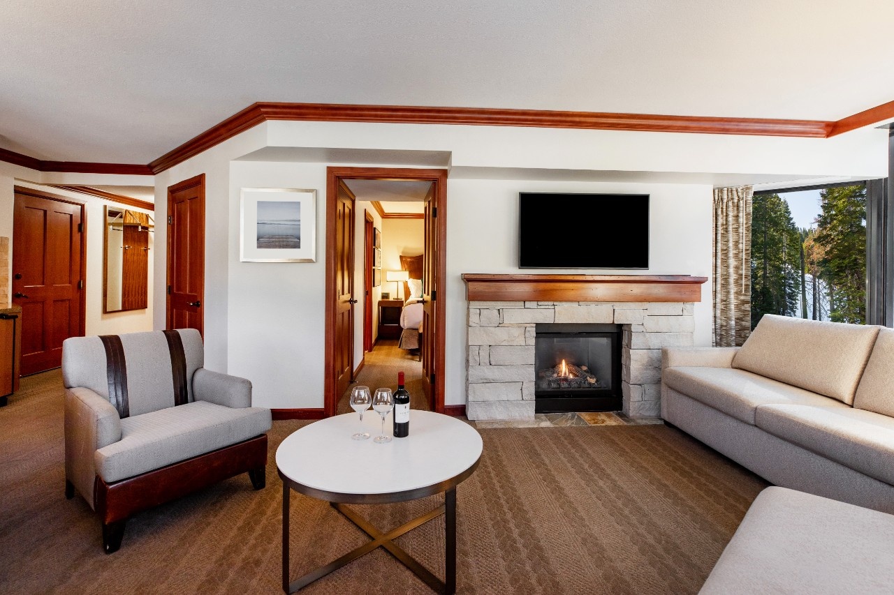 Suite living area with a fireplace and seating at Everline Resort & Spa, Palisades Tahoe, USA