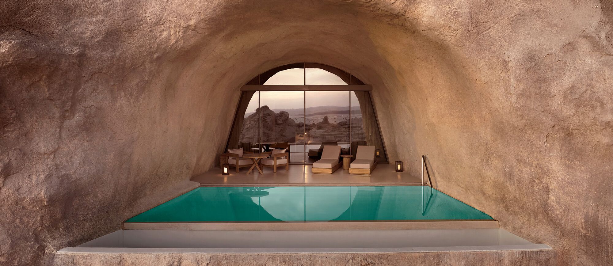 Mountain Cave Suite interior with arched window and lounge seating, Desert Rock