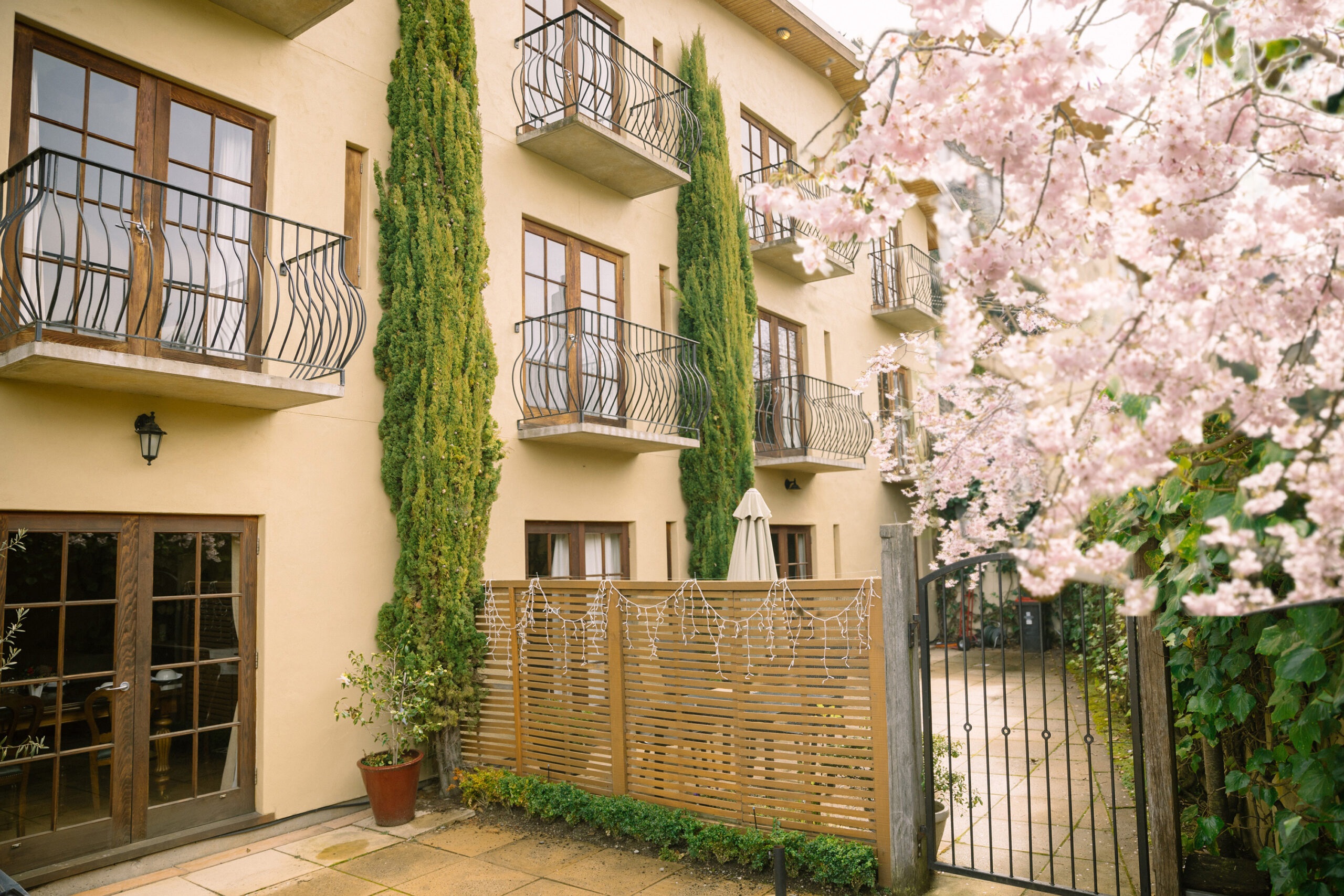 Hotel facade with Juliet balconies and flowering trees at Browns Boutique Hotel, Queenstown, New Zealand