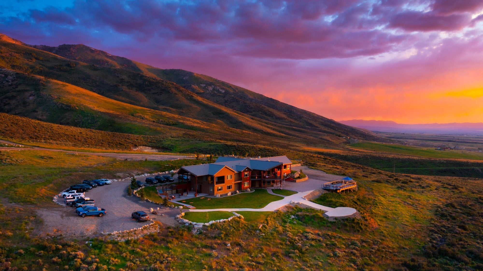 Aerial view of the lodge beneath mountain slopes at sunset at Ruby 360 Lodge, Lamoille, USA