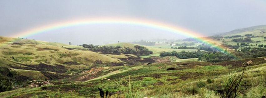 Rainbow arching over the green mountain valley, Cleopatra Mountain Farmhouse, Drakensberg, KwaZulu-Natal, South Africa