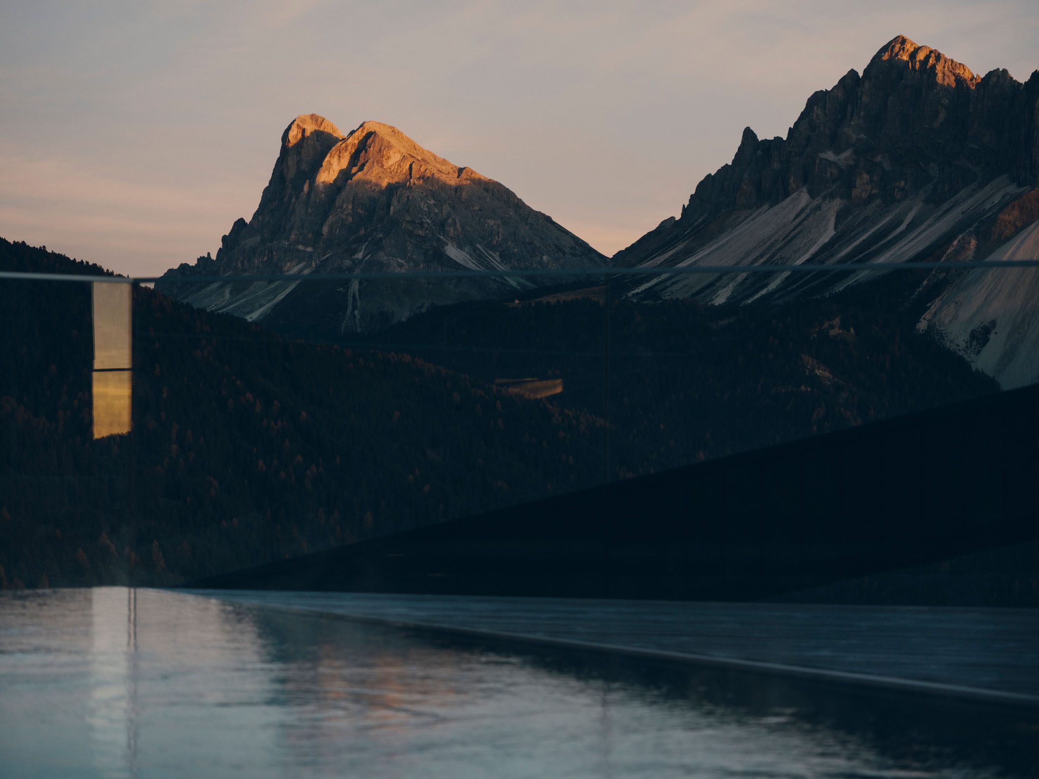 The Dolomites at dusk seen above the dark mountain landscape from FORESTIS