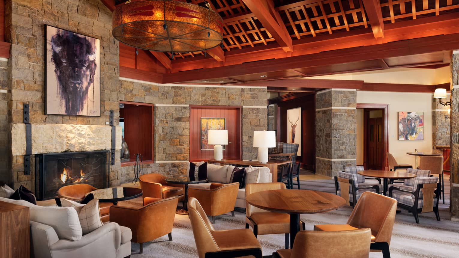 Luxury resort lounge and restaurant, with wooden beamed ceilings, stone walls, fireplace and leather chairs, Four Seasons Resort Jackson Hole, Teton Village, USA