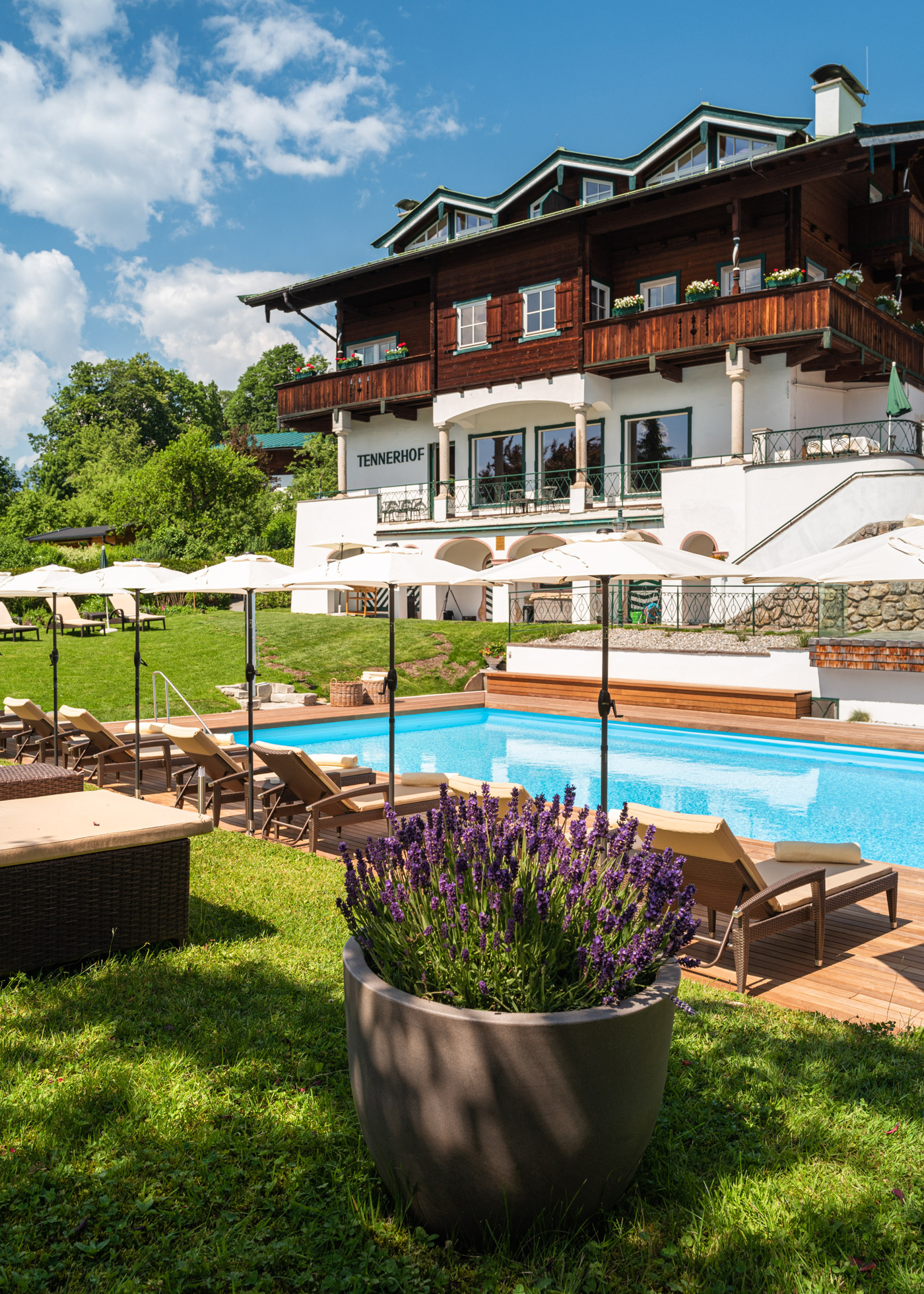 Hotel exterior and outdoor pool in summer, Tennerhof, Kitzbühel, Austria
