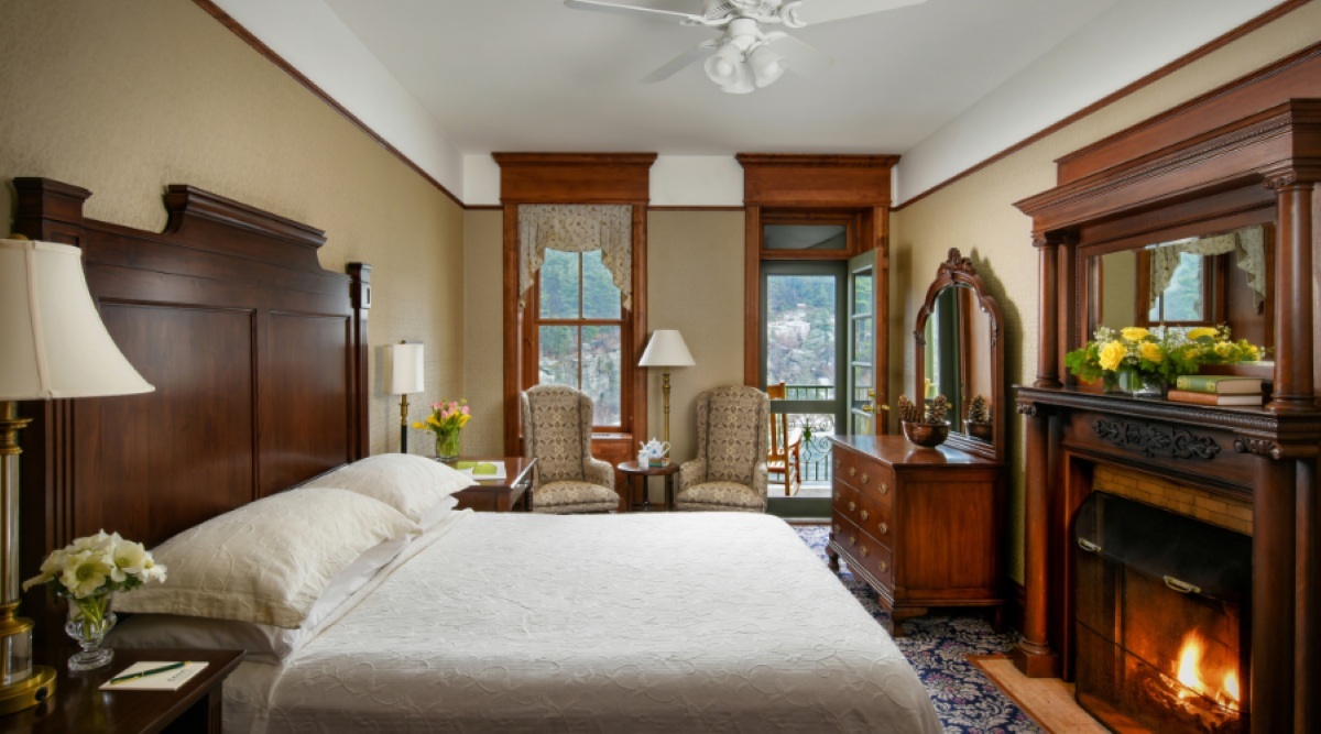 Guest bedroom with a fireplace and wooden furnishings at Mohonk Mountain House, New Paltz, USA
