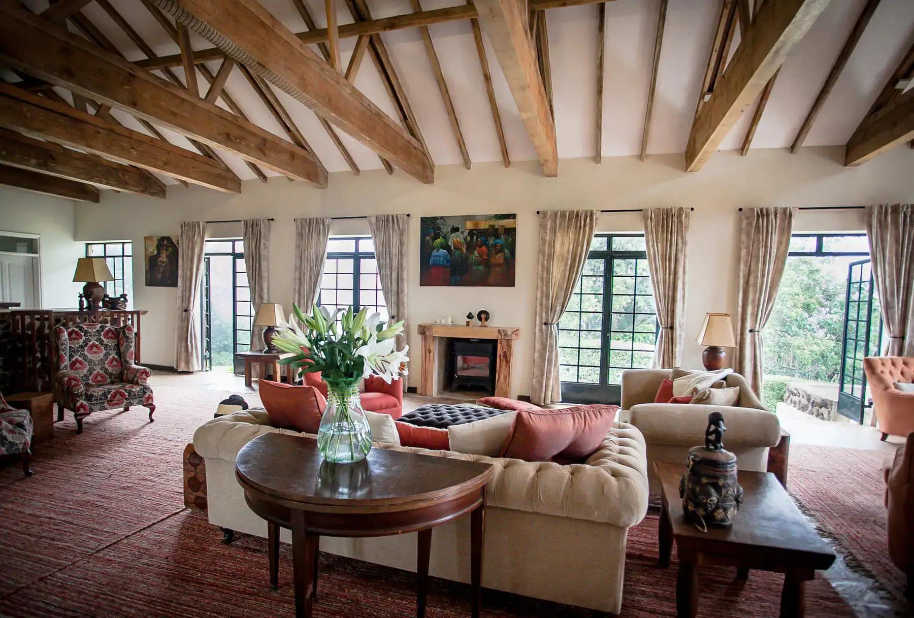 Spacious lounge with exposed timber beams and a fireplace, Clouds Mountain Gorilla Lodge, Bwindi Impenetrable National Park, Uganda