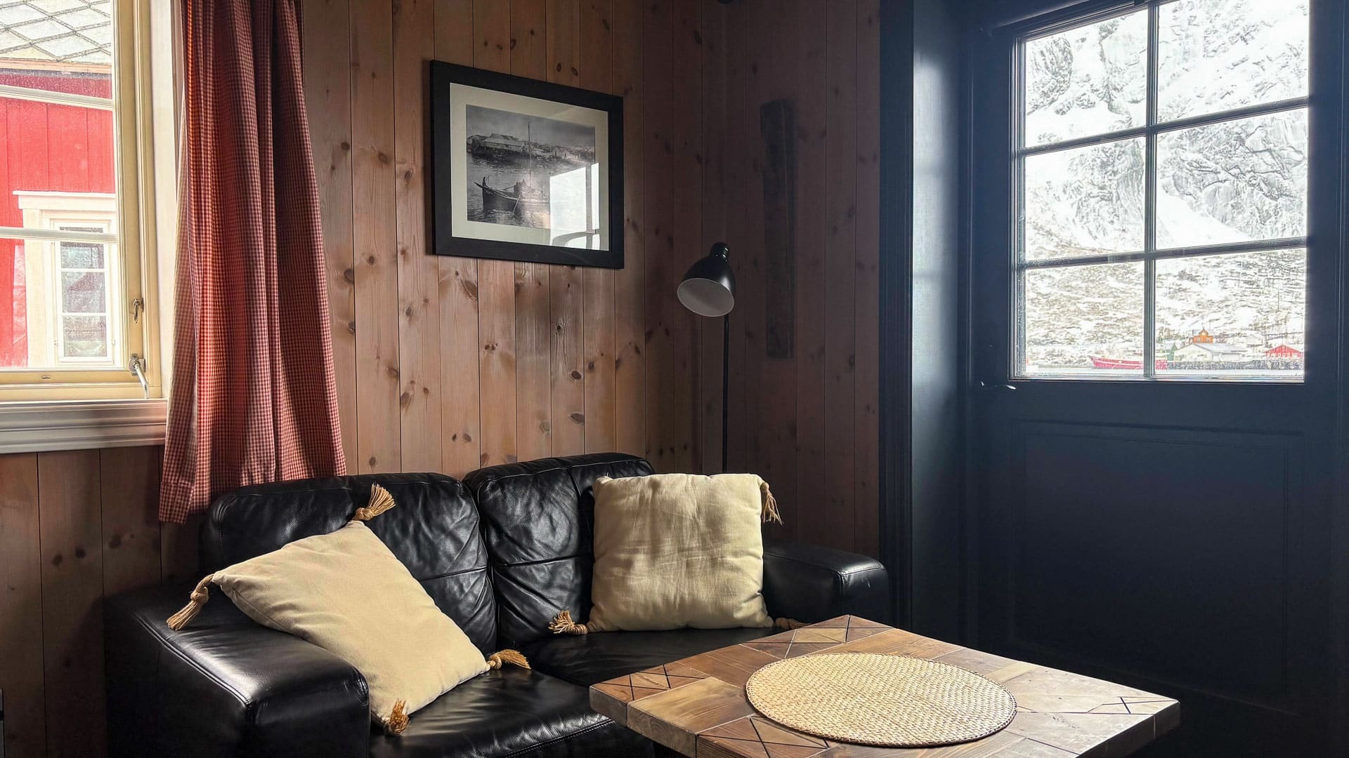 Cabin sitting area with sofa and wooden walls at Reine Rorbuer, Reine, Norway