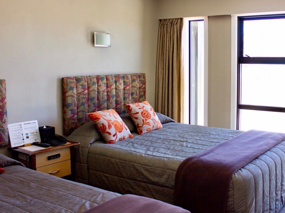 Guest room with a large bed and window at The Godley Hotel