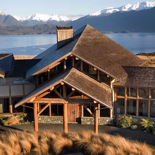 Timber Fiordland Lodge exterior overlooking Lake Te Anau and distant mountains