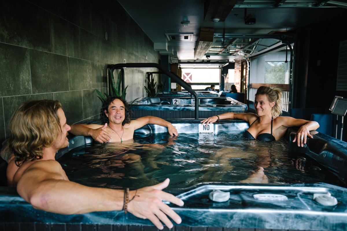 Guests relaxing in the indoor onsen-style hot tubs at Gravity Haus Breckenridge.