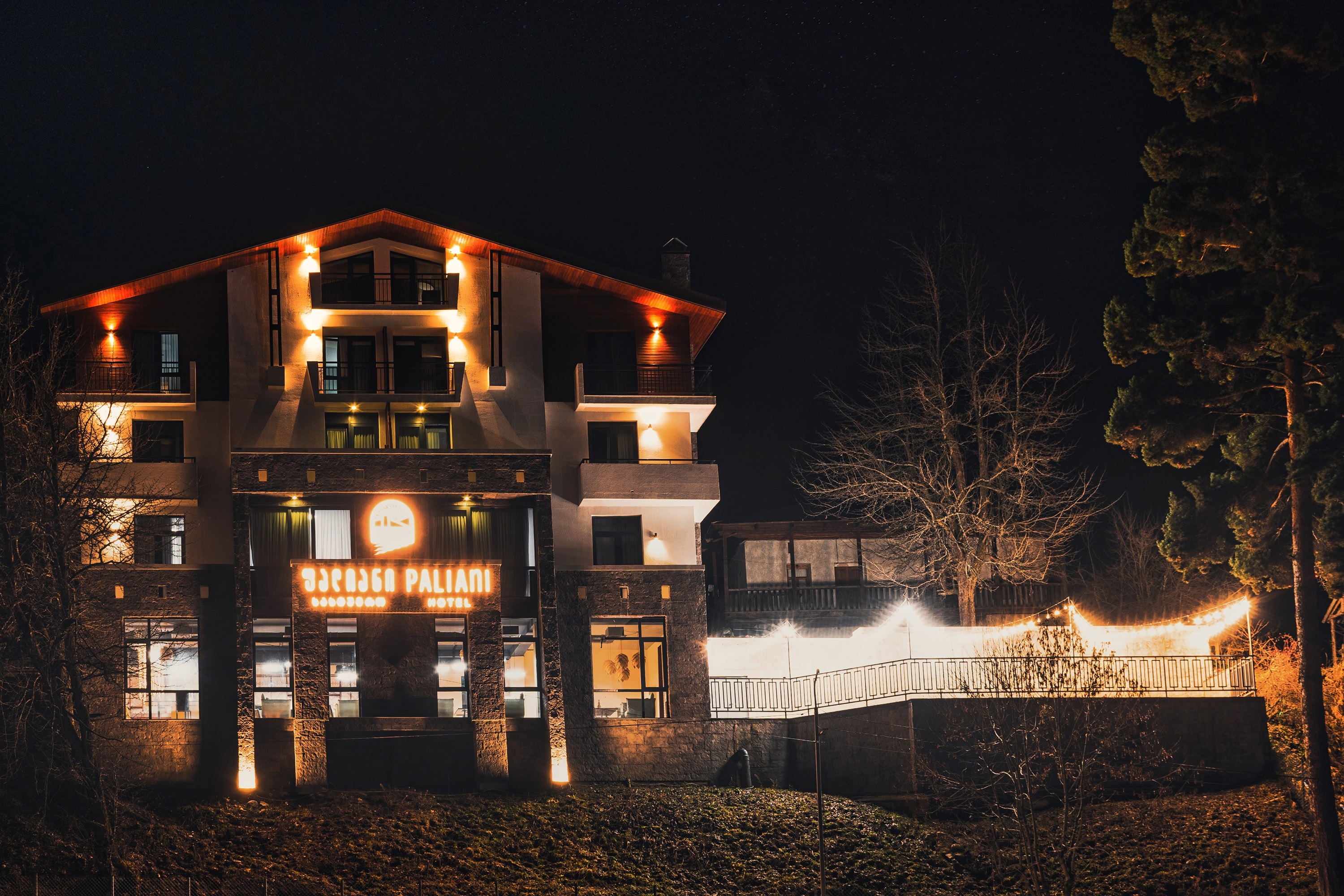 Hotel facade illuminated at night at Paliani Hotel, Mestia, Georgia