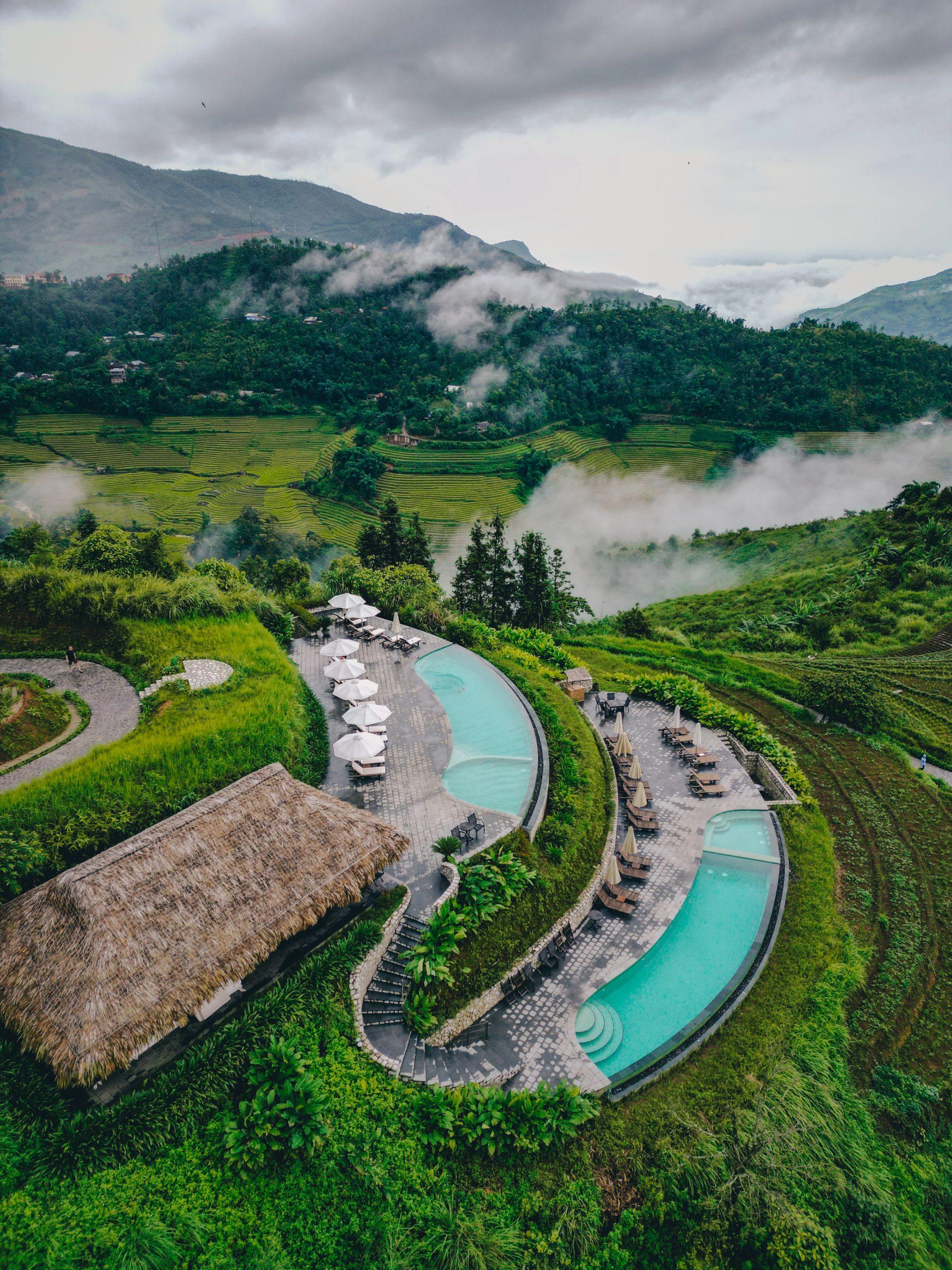 Curving infinity pools above a misty mountain valley, Topas Ecolodge, Sapa, Vietnam