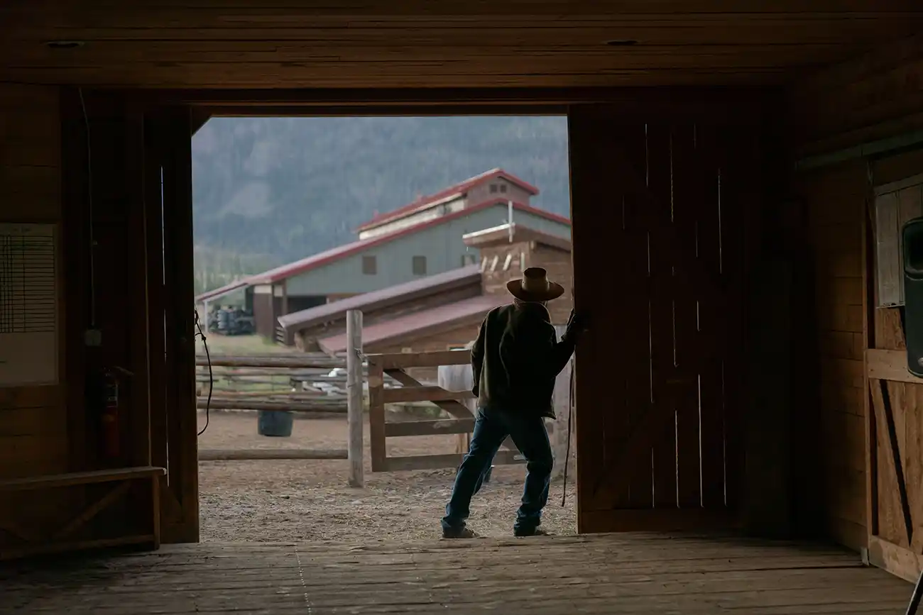 A cowboy framed by the horse-barn doorway at Vista Verde Ranch, Clark, Colorado.