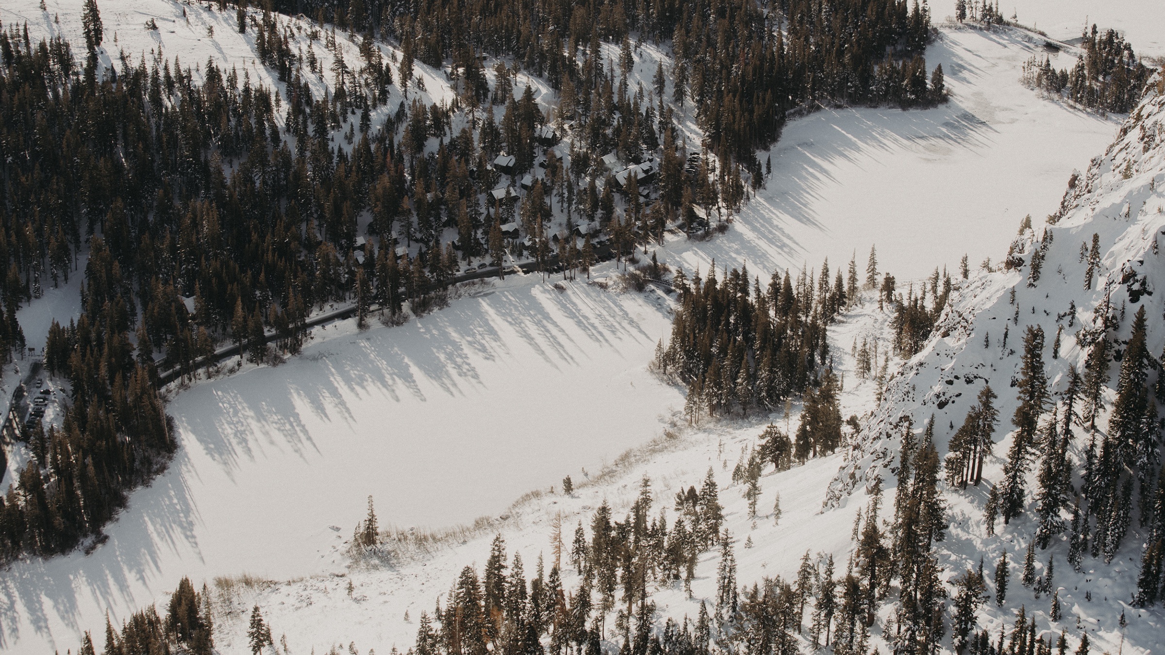 Winter aerial view of the lakeside lodge and snowy forest at Tamarack Lodge & Resort, Mammoth Lakes, USA