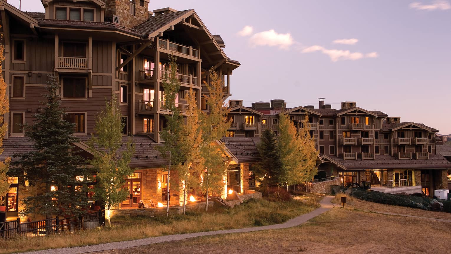 Four Seasons Jackson Hole Mountain Resort lodge exterior with lights at dusk, Four Seasons Resort Jackson Hole, Teton Village, USA