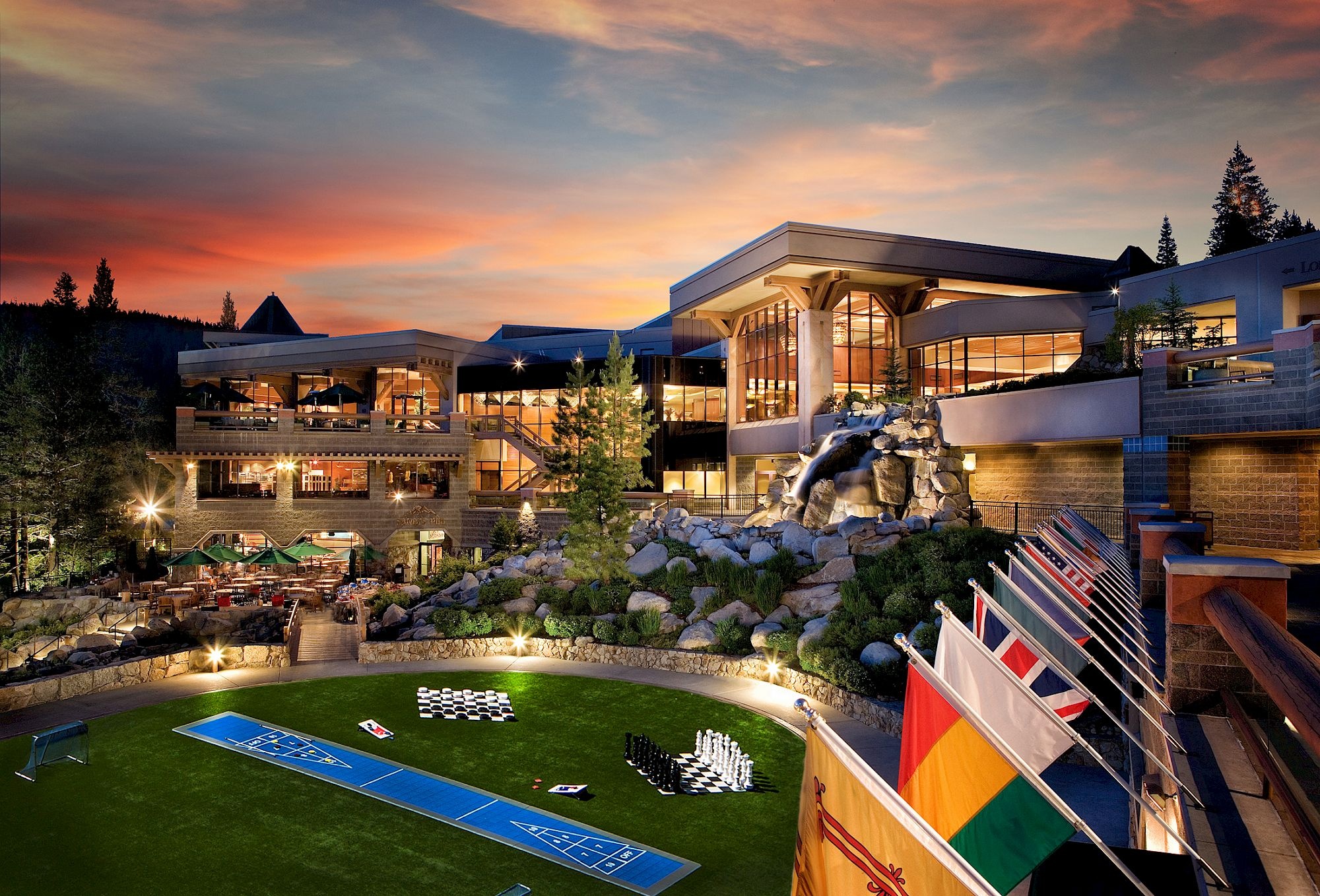 Resort courtyard and buildings illuminated at sunset at Everline Resort & Spa, Palisades Tahoe, USA