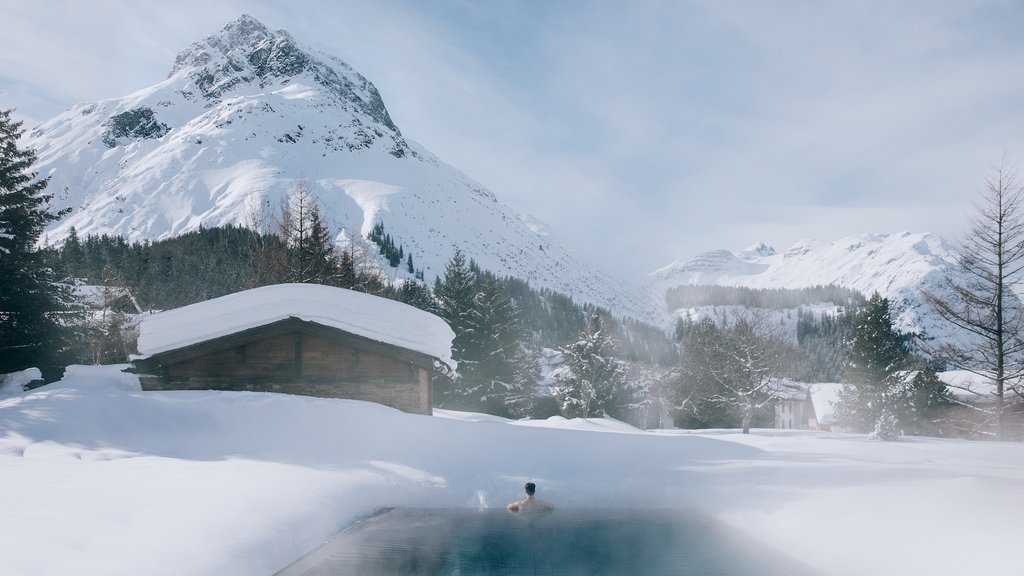 Outdoor swimming pool with snowy mountain scenery at Post Lech Arlberg, Lech, Austria