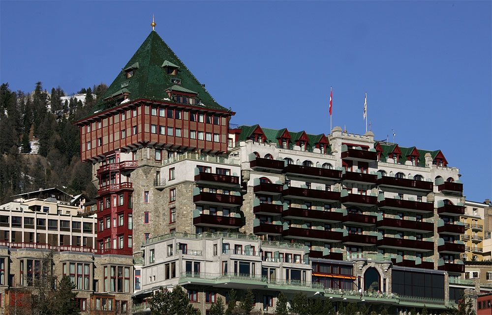 Grand hotel towers above a frozen alpine lake